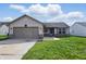 Charming single-story home featuring a two-car garage, inviting entrance and well-maintained lawn at 5213 Milhouse Rd, Indianapolis, IN 46221