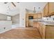 A kitchen features wood cabinets, a microwave, and a sink, with a spacious open area nearby at 5213 Milhouse Rd, Indianapolis, IN 46221