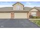 Attached two-car garage showcasing a brick facade, offering convenience and ample parking space for residents and guests at 5324 Rolling Meadow Blvd, Indianapolis, IN 46237