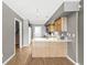 Kitchen featuring wood cabinets, breakfast bar, and hardwood floors, with stairs nearby at 5324 Rolling Meadow Blvd, Indianapolis, IN 46237