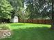 Serene backyard with lush green grass, mature trees, and a fenced perimeter at 563 Jet Stream Blvd, Westfield, IN 46074