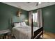 A bedroom with a vintage bed, featuring green accent wall, and a window letting in natural light at 601 Ridge Rd, Greenwood, IN 46142