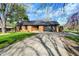 Brick home with an attached garage, driveway, and green lawn with a mature tree on the side at 601 Ridge Rd, Greenwood, IN 46142