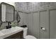 Charming powder room with patterned wallpaper, grey wainscoting and a dark-stained vanity at 601 Ridge Rd, Greenwood, IN 46142