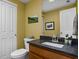 Bathroom with yellow walls, wood cabinets, granite countertop, and new toilet at 675 Greenford N Trl, Carmel, IN 46032