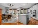 Cozy living room with hardwood floors, large windows, and a ceiling fan, adjacent to the kitchen at 675 Greenford N Trl, Carmel, IN 46032
