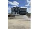 A two-story home with a dark exterior, shuttered windows and a concrete driveway under a partly cloudy sky at 7167 Finley Creek Dr, Whitestown, IN 46075