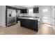 A modern kitchen featuring black cabinets, an island, stainless steel appliances, and wood floors at 7167 Finley Creek Dr, Whitestown, IN 46075
