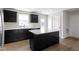 A contemporary kitchen with black cabinets, a center island, and stainless steel appliances at 7167 Finley Creek Dr, Whitestown, IN 46075