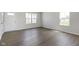 Bright living room featuring wood floors, a white door, and two large windows at 7167 Finley Creek Dr, Whitestown, IN 46075