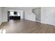 Open-concept living room with wood floors, staircase, and views into the kitchen at 7167 Finley Creek Dr, Whitestown, IN 46075