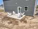 Backyard view of the patio with a set of four white Adirondack chairs and side tables at 7167 Finley Creek Dr, Whitestown, IN 46075