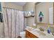 Traditional bathroom features decorative shower curtain, vanity with sink, and framed mirror at 7714 Black Walnut Dr, Avon, IN 46123
