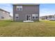 Shot of backyard of home, siding, windows, concrete patio, and a well-maintained lawn at 8546 Strabet Dr, Pendleton, IN 46064