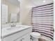 Clean bathroom with a white vanity, large mirror, and a shower with a stylish striped curtain at 8546 Strabet Dr, Pendleton, IN 46064