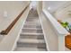 Carpeted staircase with a wooden handrail and white trim, leading to the upper level at 8546 Strabet Dr, Pendleton, IN 46064