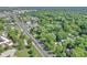 Aerial view of a neighborhood with many trees and a long street with cars at 8553 Broadway St, Indianapolis, IN 46240