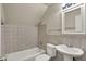 Tiled bathroom featuring a shower over tub, white toilet, and sink with vanity at 8553 Broadway St, Indianapolis, IN 46240