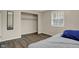 This bedroom features neutral walls, wood floors, a closet, and a window with blinds at 8553 Broadway St, Indianapolis, IN 46240