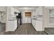 Clean and functional kitchen with white cabinetry, sleek appliances, and gray wood flooring at 8553 Broadway St, Indianapolis, IN 46240