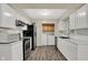 Charming kitchen featuring white cabinets and modern appliances, and a laundry area at the end at 8553 Broadway St, Indianapolis, IN 46240