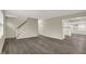 Open-concept living area with gray wood floors, a staircase, and a view into the kitchen at 8553 Broadway St, Indianapolis, IN 46240