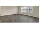 Bright living room featuring gray wood flooring, a large window, and neutral wall color at 8553 Broadway St, Indianapolis, IN 46240