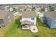 Aerial view of the backyard featuring a covered patio with seating and a cozy fire pit area at 8663 Kellner St, Pendleton, IN 46064