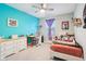 Bedroom with a bright accent wall, ceiling fan, large dresser, desk, and vibrant decorations at 8663 Kellner St, Pendleton, IN 46064