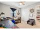 A well-lit bedroom with nautical decor, a dark wood desk, ceiling fan, and blue accent chair at 8663 Kellner St, Pendleton, IN 46064