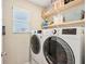 Modern laundry room with a window, light wood shelving, and new, energy-efficient washer and dryer at 8663 Kellner St, Pendleton, IN 46064