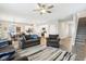 Open-concept living room features modern lighting, wood floors, gray sofas and flows into the kitchen at 8663 Kellner St, Pendleton, IN 46064
