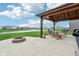 Backyard patio features a pergola, pond view, outdoor seating, a fire pit, and a grill at 8663 Kellner St, Pendleton, IN 46064