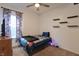 Bedroom showcasing a ceiling fan and natural light from the window, with floating shelves on the side wall at 944 Redwood Dr, Franklin, IN 46131