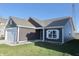 A bright shot of a one-story home, brown siding and white trim, sunny and manicured at 944 Redwood Dr, Franklin, IN 46131