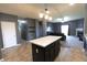 Open concept kitchen with island featuring dark cabinets, a view into the living room, and laminate floors at 944 Redwood Dr, Franklin, IN 46131
