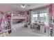 Bright pink bedroom features a lofted bed over a desk area and open window with blinds at 9760 Logan Ln, Fishers, IN 46037