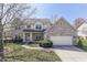Charming two-story brick home with a well-manicured lawn and attached two-car garage at 9760 Logan Ln, Fishers, IN 46037