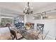 Open-concept dining area with glass table, chandelier, mirrors, and seamless flow into the adjacent living space at 1014 Sugar Maple Dr, Greenwood, IN 46143