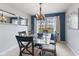 Bright dining room featuring a glass table, modern chandelier, and large window with neighborhood views at 1014 Sugar Maple Dr, Greenwood, IN 46143
