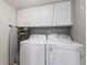 Convenient laundry room equipped with white cabinetry, modern appliances, and stylish wallpaper at 1014 Sugar Maple Dr, Greenwood, IN 46143