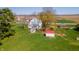 Aerial view of a white two-story farmhouse, sheds, and green yard with mature trees at 10723 E State Road 234, Wilkinson, IN 46186