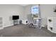Bright room with carpet, desk, white shelves, tv, and a comfy white gaming chair in front of a sunlit window at 10844 Tedder Lake Dr, Indianapolis, IN 46239