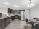 Eat-in kitchen features stainless steel appliances, dark wood cabinets, granite counters, and hardwood floors at 10844 Tedder Lake Dr, Indianapolis, IN 46239