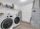 Functional laundry room with modern washer, dryer, shelving, and water heater at 10844 Tedder Lake Dr, Indianapolis, IN 46239
