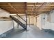 Unfinished basement with stairs, exposed beams, and painted floor, offering potential for customization at 1234 E 71St St, Indianapolis, IN 46220