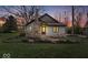 Charming home with stone chimney and landscaped front yard during dusk at 1234 E 71St St, Indianapolis, IN 46220
