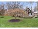 Charming front yard featuring a lush lawn, a blossoming tree, and the home's quaint exterior, adding curb appeal at 1234 E 71St St, Indianapolis, IN 46220