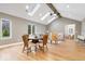 Bright living room with vaulted ceilings, hardwood floors, skylights, and a seamless transition to the dining area at 1234 E 71St St, Indianapolis, IN 46220