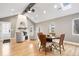 Open-concept living room featuring a cozy fireplace, hardwood floors, and a vaulted ceiling with skylights at 1234 E 71St St, Indianapolis, IN 46220